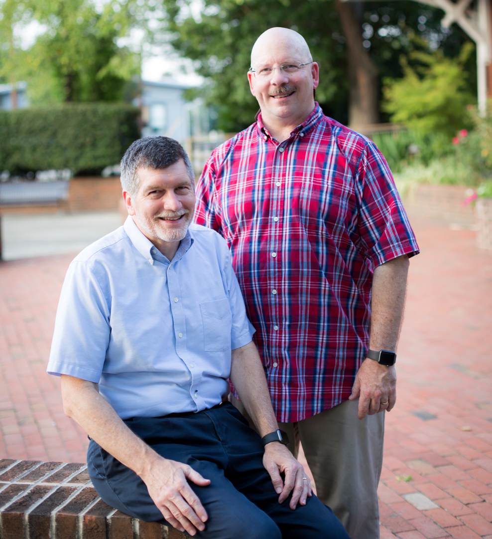 Two Certified IT consultants stand for a photo together in a business area.